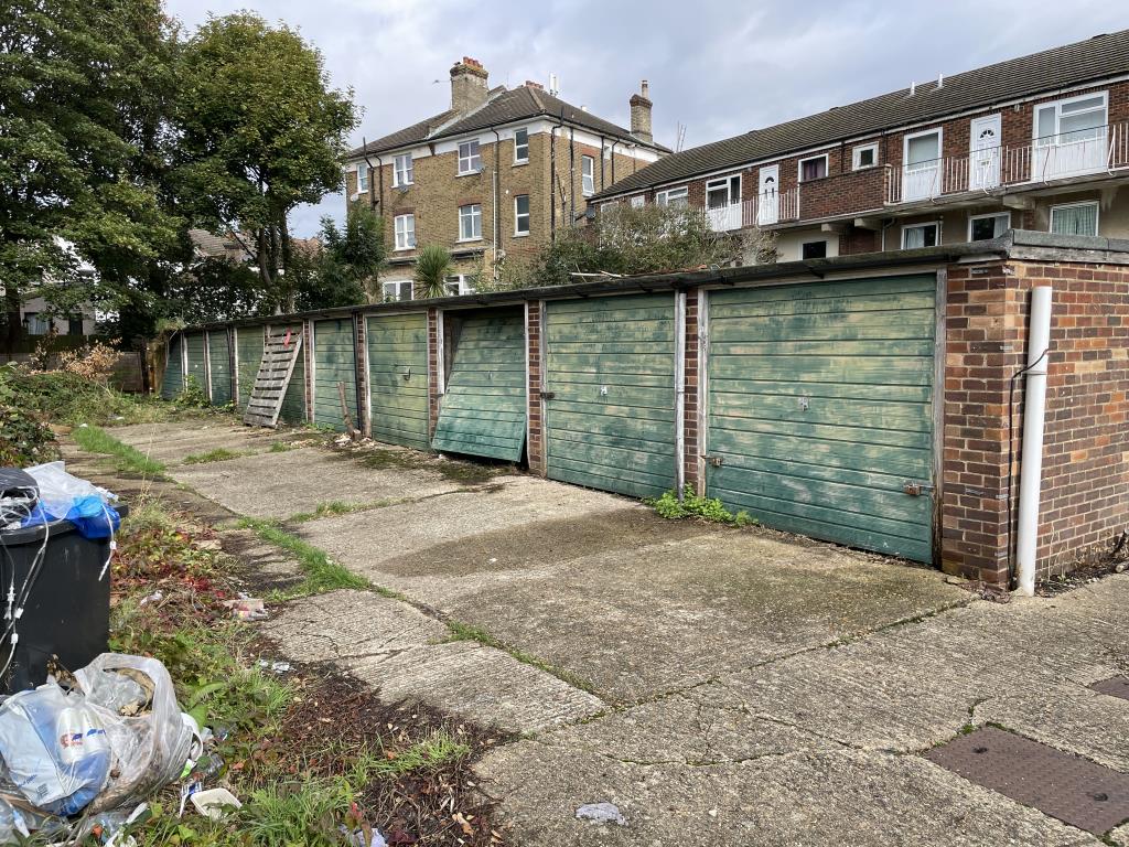 Lot: 100 - FREEHOLD GARAGE SITE WITH POTENTIAL FOR REDEVELOPMENT, SUBJECT TO PLANNING APPROVAL - Exterior view of garages at back of building